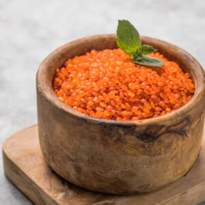 Red lentil whole grain in a wooden bowl